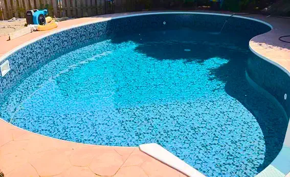 Backyard pool after liner replacement, clear water and modern look