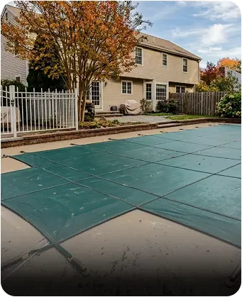 Pool safety cover securely installed over backyard swimming pool